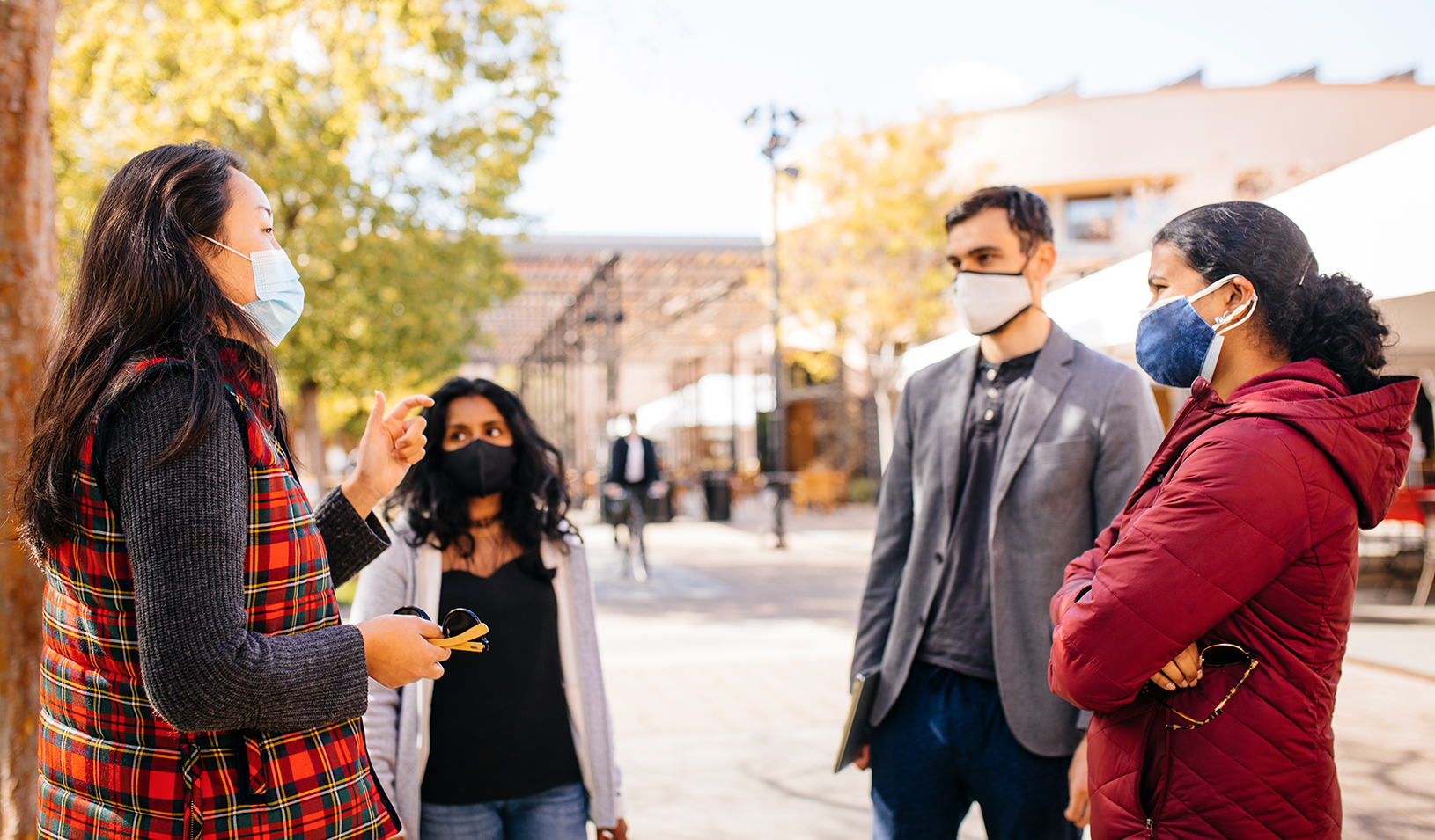 A group of masked students stop to talk in Town Square on campus. Credit: Elena Zhukova