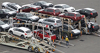 Three trucking trailers loaded with cars