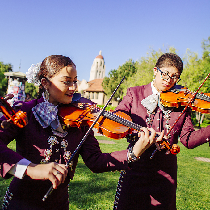 International students in traditional costumes playing the violins