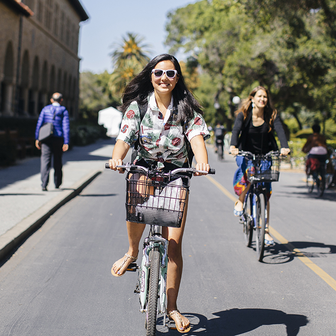 Women riding bikes on campus