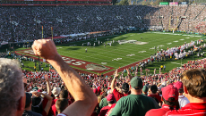 Fans in audience cheer on Stanford's football team at the Stanford Stadium