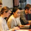 Three students looking at a laptop. 