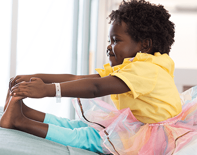 Young patient reaching for her toes in a ballerina tutu